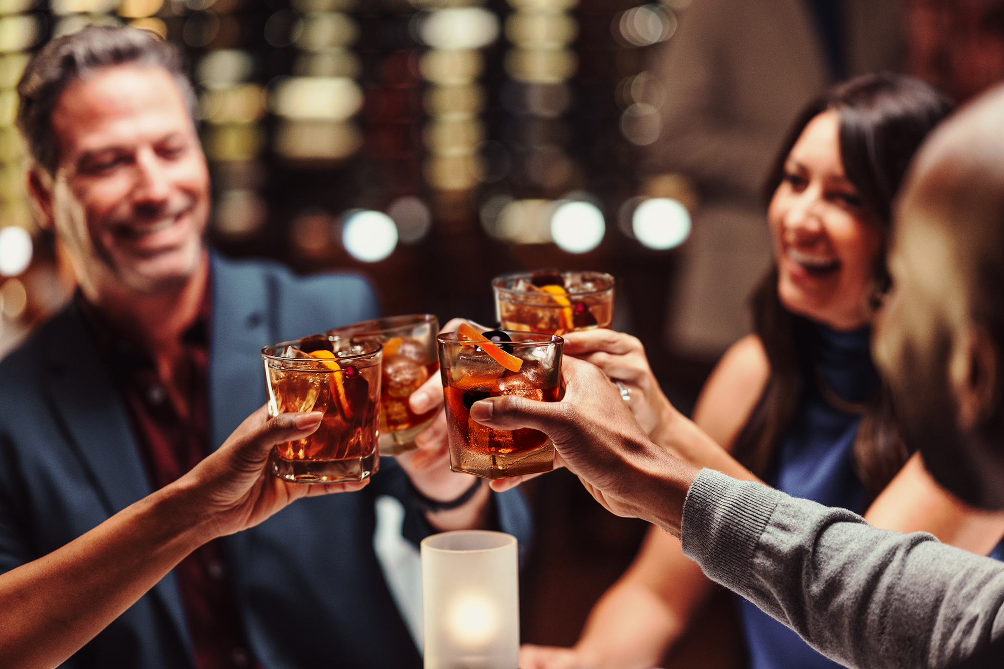A group of friends toasting Old Fashioneds